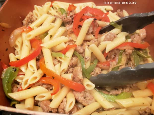 After draining pasta, the peppers, onions and sausage are added to the pasta in pan.