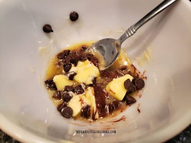 Butter and chocolate chips are melted in a microwave safe bowl.