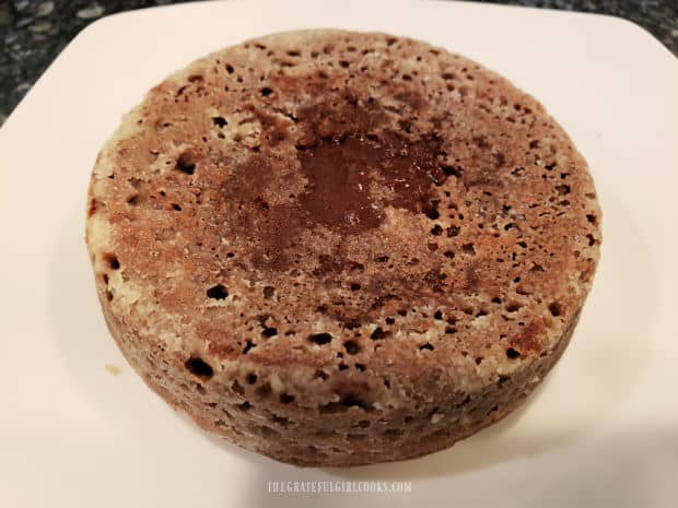 After cooling for 5 minutes, the air fryer chocolate lava cake is inverted onto a plate.