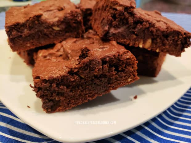 A white plate with several unfrosted brownies ready to enjoy.