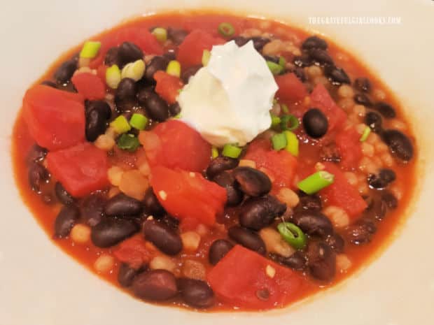 A white bowl full of easy black bean stew is ready to be eaten and enjoyed.