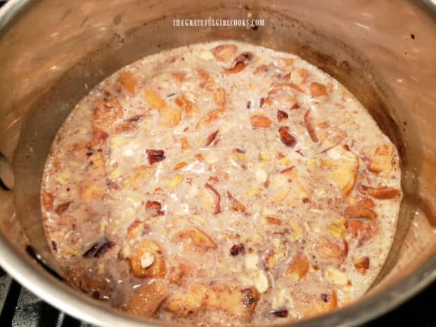 The oatmeal and added ingredients cook in the saucepan until thickened.