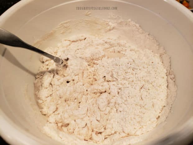 Flour and salt are stirred into the water and yeast to form a sticky bread dough.