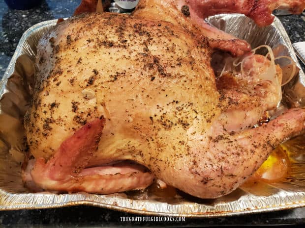 Halfway through cooking time, turkey is basted with juices from pan, then covered with foil.