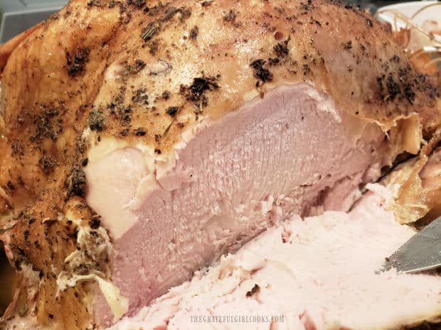 The smoked whole turkey is cut into slices and served.
