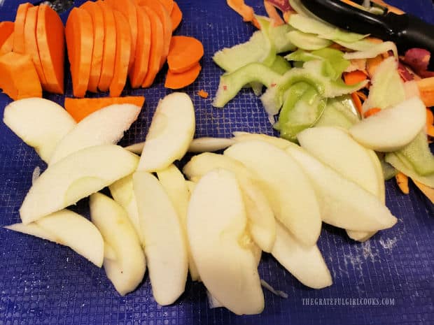 An apple is peeled, then cut into thin slices, along with a sweet potato.