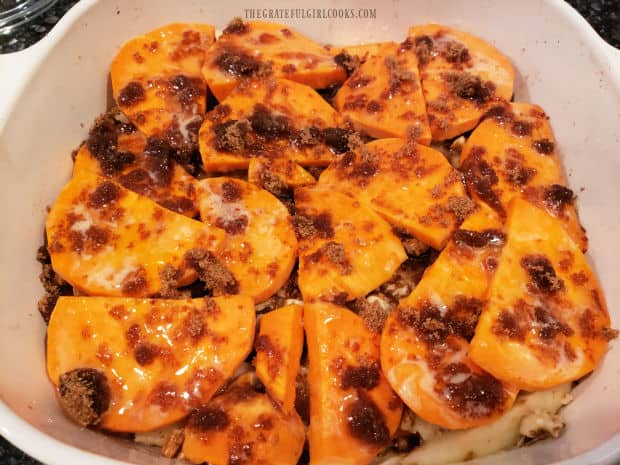 The sweet potato apple bake is covered with melted butter and brown sugar.