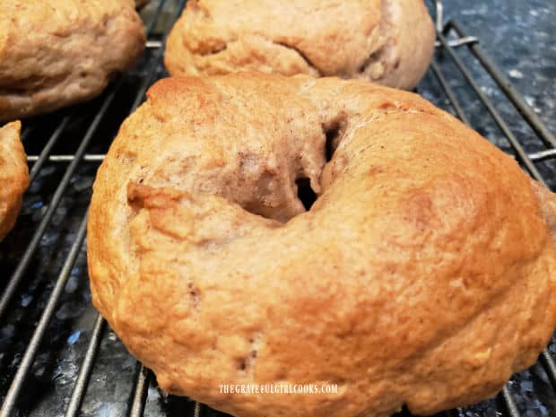 A close up of one of the banana nut bagels cooling on a wire rack.