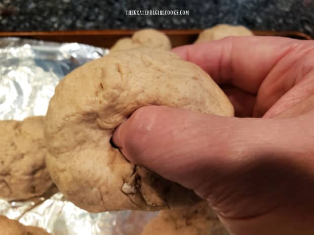 Using fingers, a hole is made in the center of each of the 9 bagel dough balls.