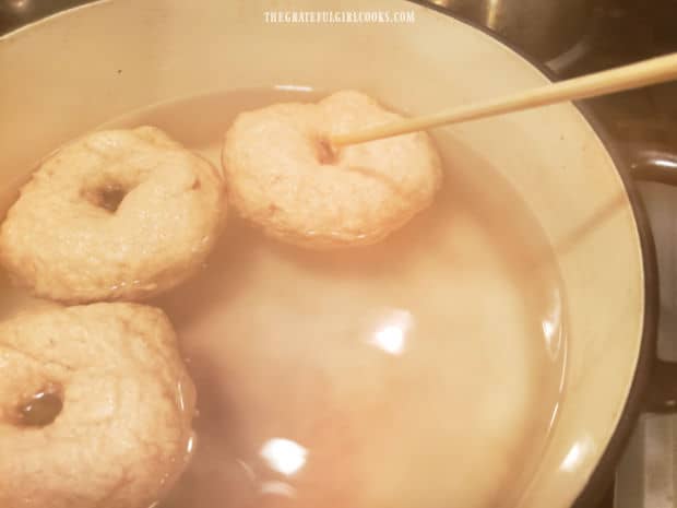 The bagels are boiled, a few at a time, in hot simmering water.