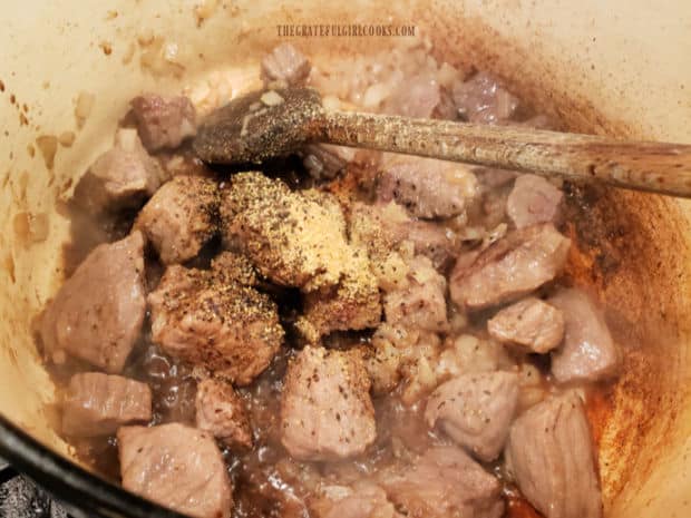 Spices and Worcestershire sauce are added to the beef and onions in pan.