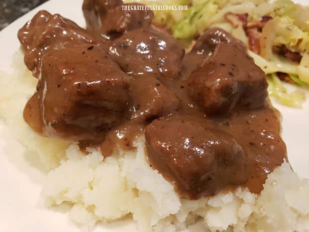 A bed of mashed potatoes provides the base for the beef tips and gravy.