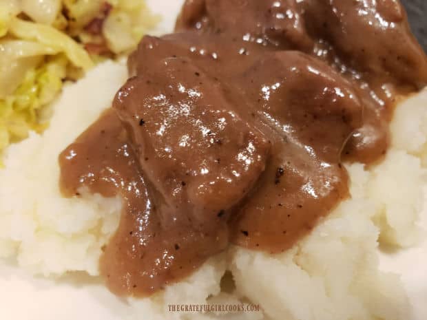 A portion of the beef tips and gravy, served on top of creamy mashed potatoes.