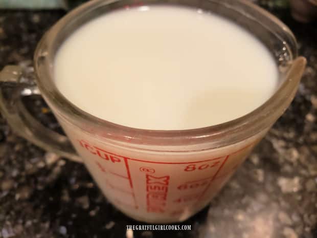 A cup of milk is heated slightly in a microwave before adding to egg mixture.