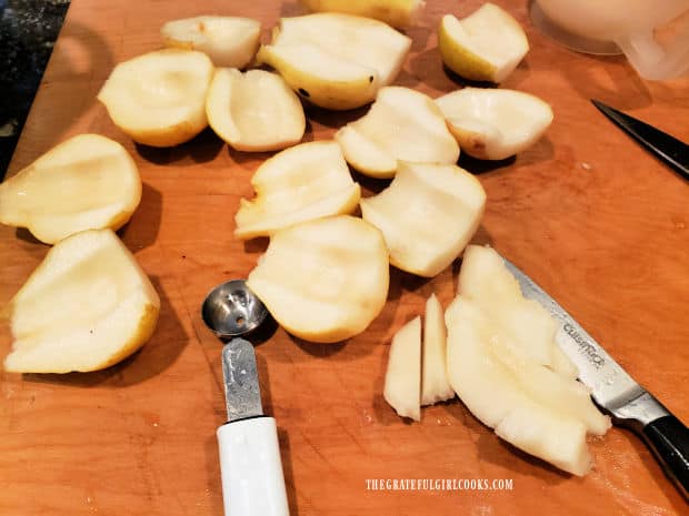 Ripe pears are prepped by peeling and removing cores.