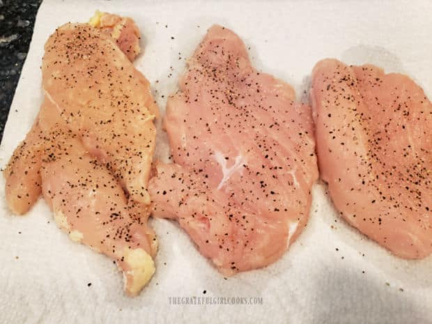 Chicken breasts are patted dry, then seasoned with salt and pepper before cooking.
