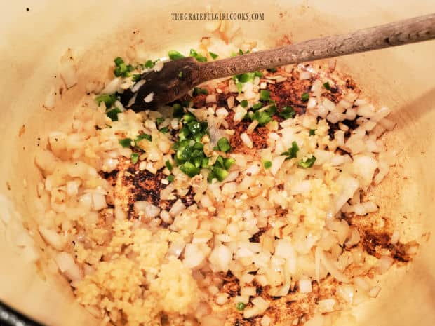 Minced garlic and diced jalapeños are added to onions in pan and cooked.