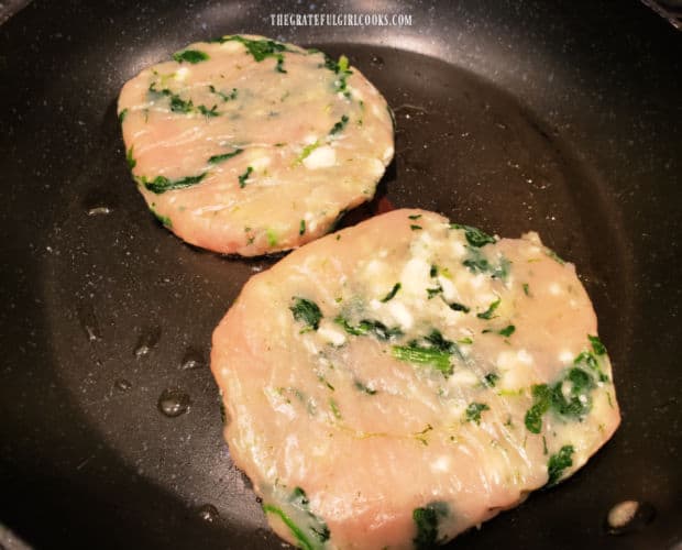 Turkey burgers cooking in a lightly oiled large skillet.