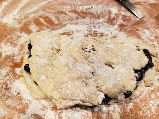 Half of the biscuit dough is pulled up and over the blueberries.