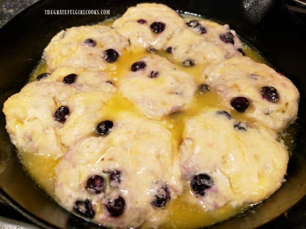 Melted butter is poured over the partially baked biscuits, then skillet goes back into oven.