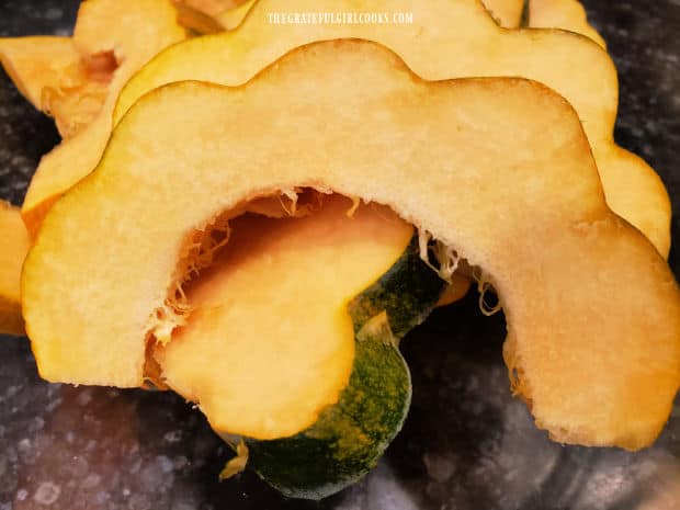 The acorn squash slices resemble a half-moon in shape after being cut.