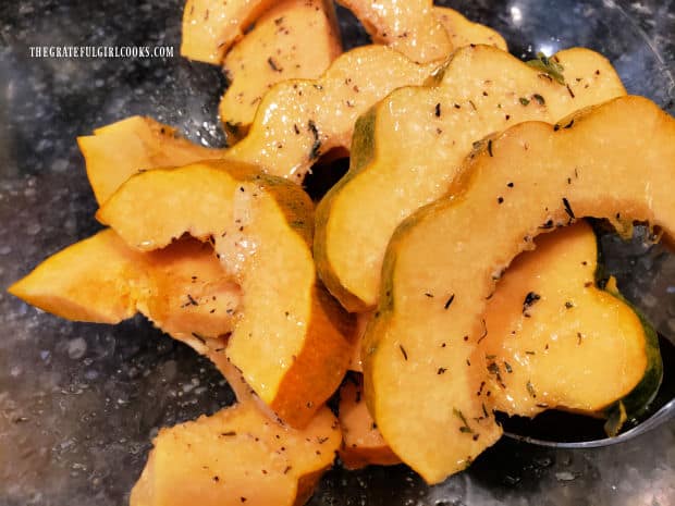 All the acorn squash slices are gently tossed to coat them with butter/spice mixture.