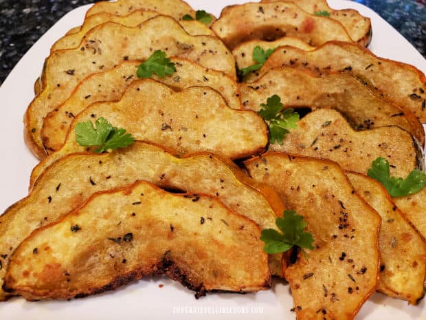 The roasted Parmesan acorn squash is garnished with fresh parsley and served.