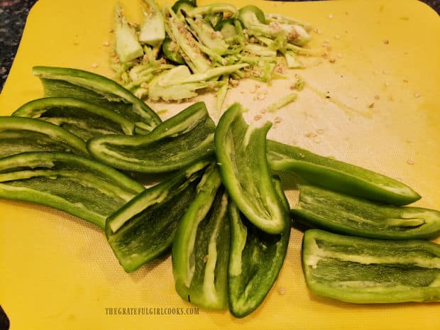 The peppers are sliced lengthwise in half, then the seeds are removed (and discarded).