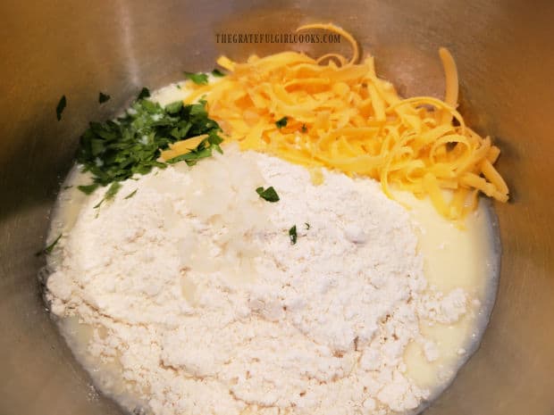 Cheddar cheese, chopped parsley, minced onion, and biscuit mix are combined with egg mixture.