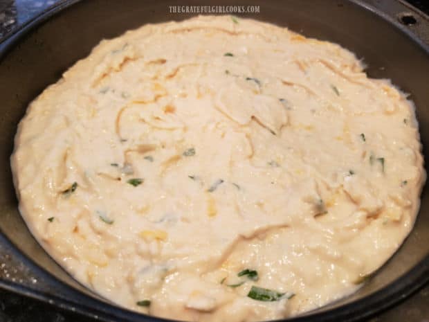 After batter for the cheesy bread wedges is combined, it's placed in a greased cake pan.