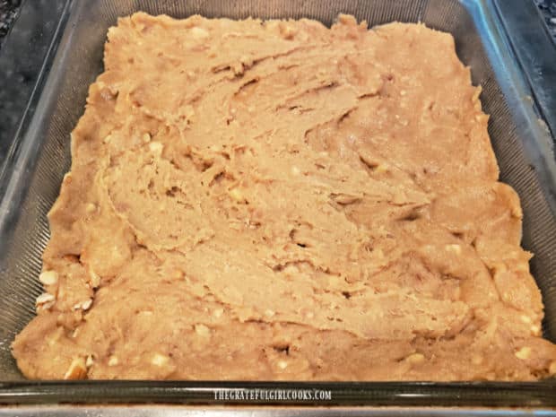 Dough for the chocolate chip swirl bars is spread in a greased baking dish.