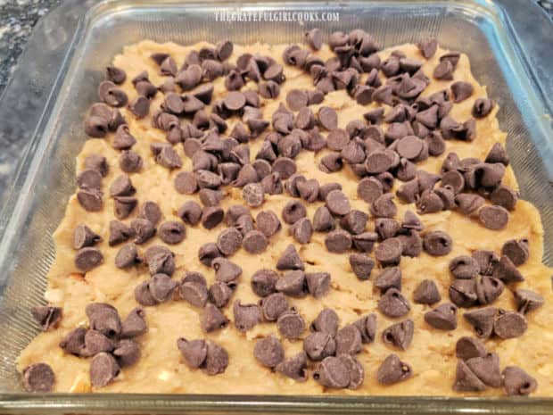 Chocolate chips are sprinkled over the surface of the dough.