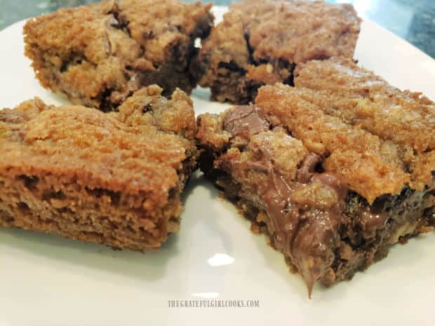 Four of the chocolate chip swirl bars are served on a white plate.