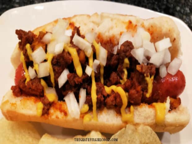 Mustard and chopped onions are added to the top of one of the Coney dogs to enjoy. 
