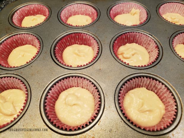Muffin cups are filled only halfway with the batter for raspberry surprise muffins.