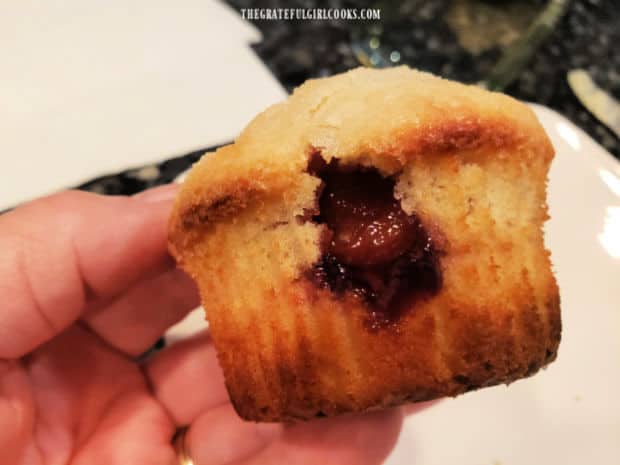 A bite taken from the muffin shows the surprise raspberry filling inside the muffin.