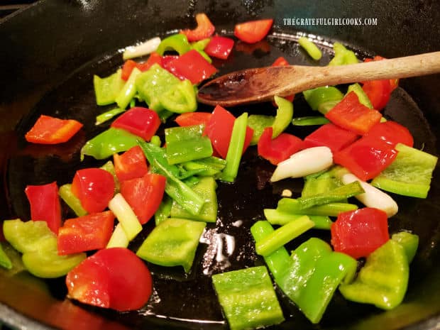 Green onions and red and green bell peppers are quickly stir-fried in hot oil in skillet.