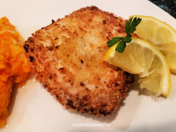 An Air fryer crusted mahi mahi filet is served with a lemon wedge on the side.