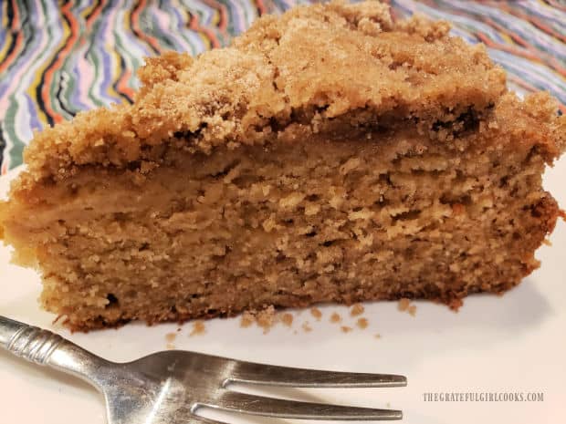 One slice of the banana streusel coffeecake, on a white plate, ready to be eaten.