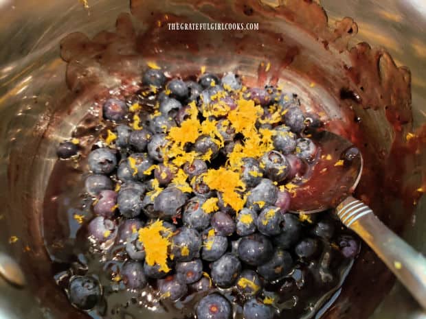 Grated lemon zest and fresh (or frozen, but thawed) blueberries are added to the saucepan.
