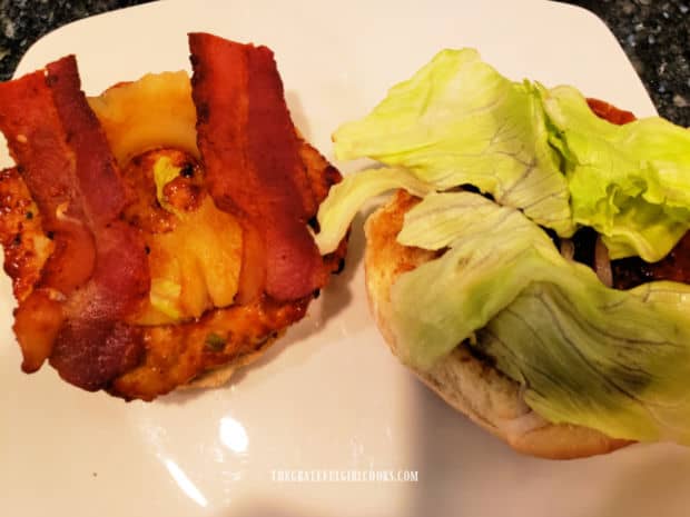 Layering on the condiments on top of the grilled chicken burger patty.