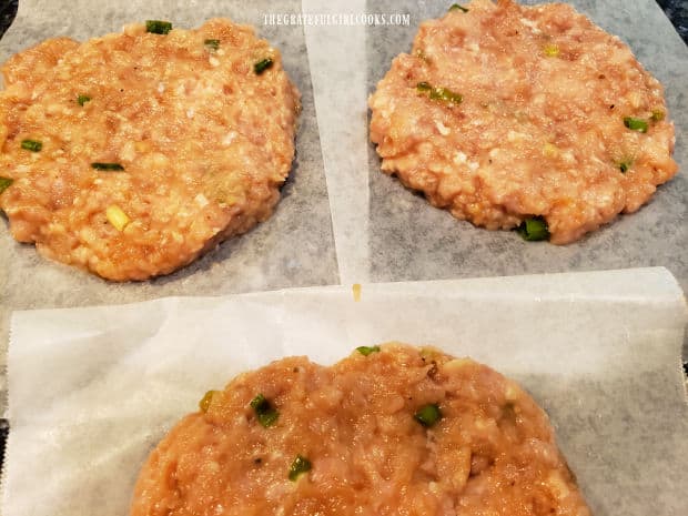 Chicken burger mixture is shaped into round burger patties before cooking.
