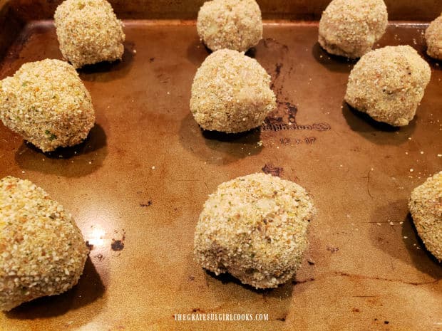 Bread crumb-coated turkey croquettes are placed on baking sheet to cook in the oven.