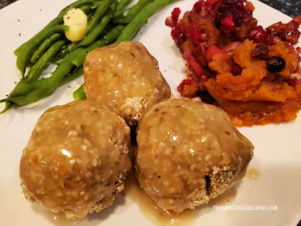 Classic turkey croquettes are covered with gravy, and served with green beans and yams on the side.