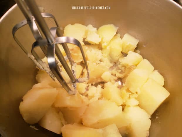 The cooked potatoes are mashed with an electric mixer until lump-free.