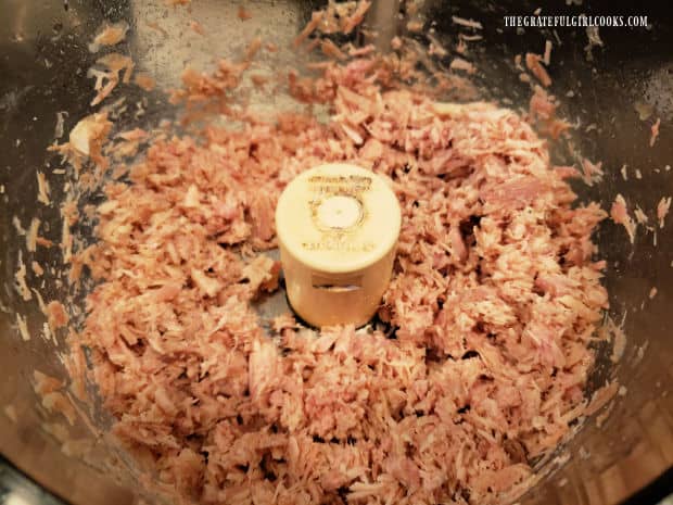 Pieces of leftover turkey are minced, using a food processor.