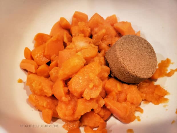 Drained canned yams, salt and brown sugar are combined in a medium bowl.