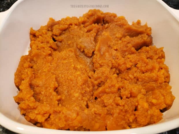 Mashed brown sugar yams are spread in a greased 2 quart baking dish.