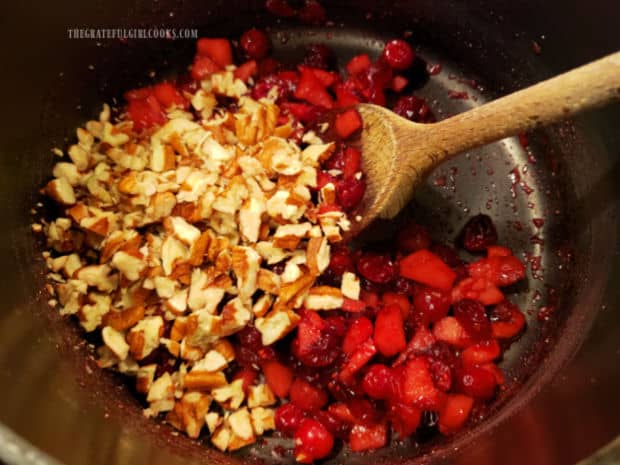Chopped nuts (walnuts or pecans) are stirred into cranberry/apple mixture in pan.