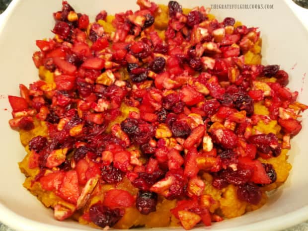 The cranberry/apple/nut mixture is spread on top of the mashed yams in baking dish.
